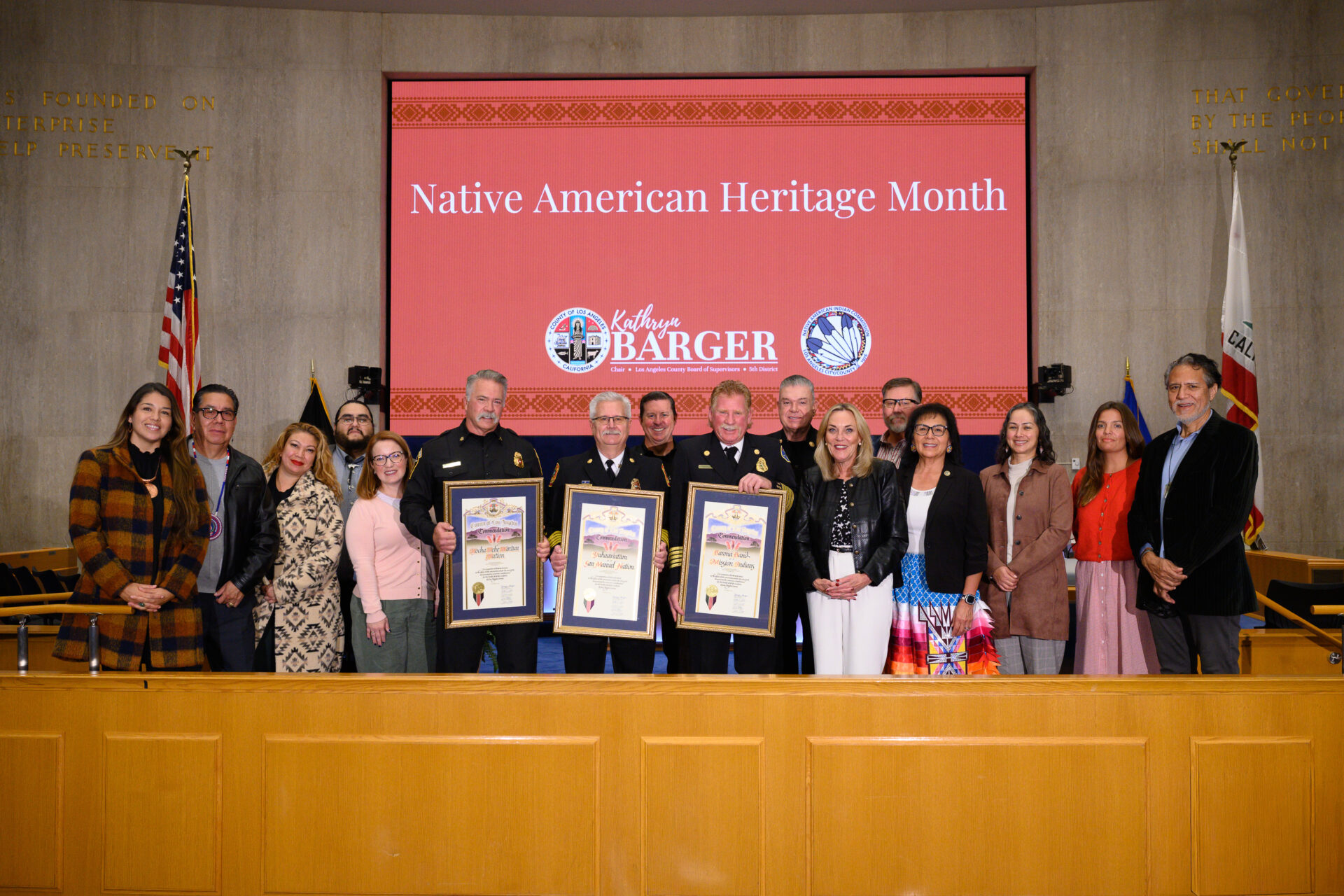 Supervisor Barger stands in the Board room alongside honorees and commissioners.