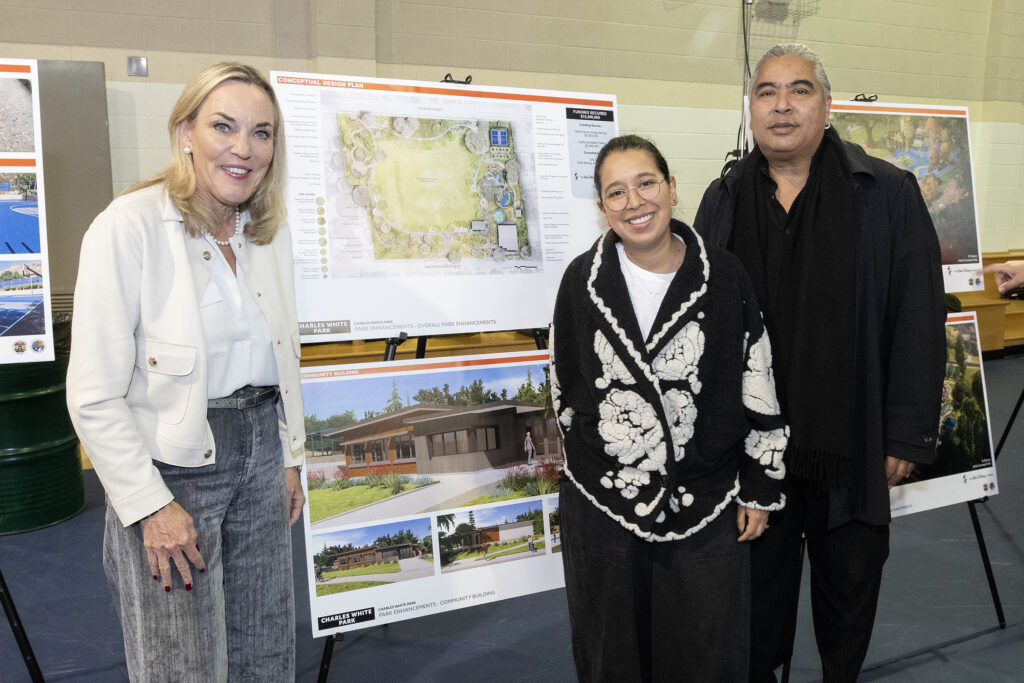 Supervisor Kathryn Barger poses in front of rendering of the future Charles White Park Community Center and park plan, alongside Paulina Alvarez and Ian White, son of the park's namesake, Charles White.