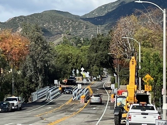 View of Lincoln Avenue Bridge with cars on the road and mountains behind.