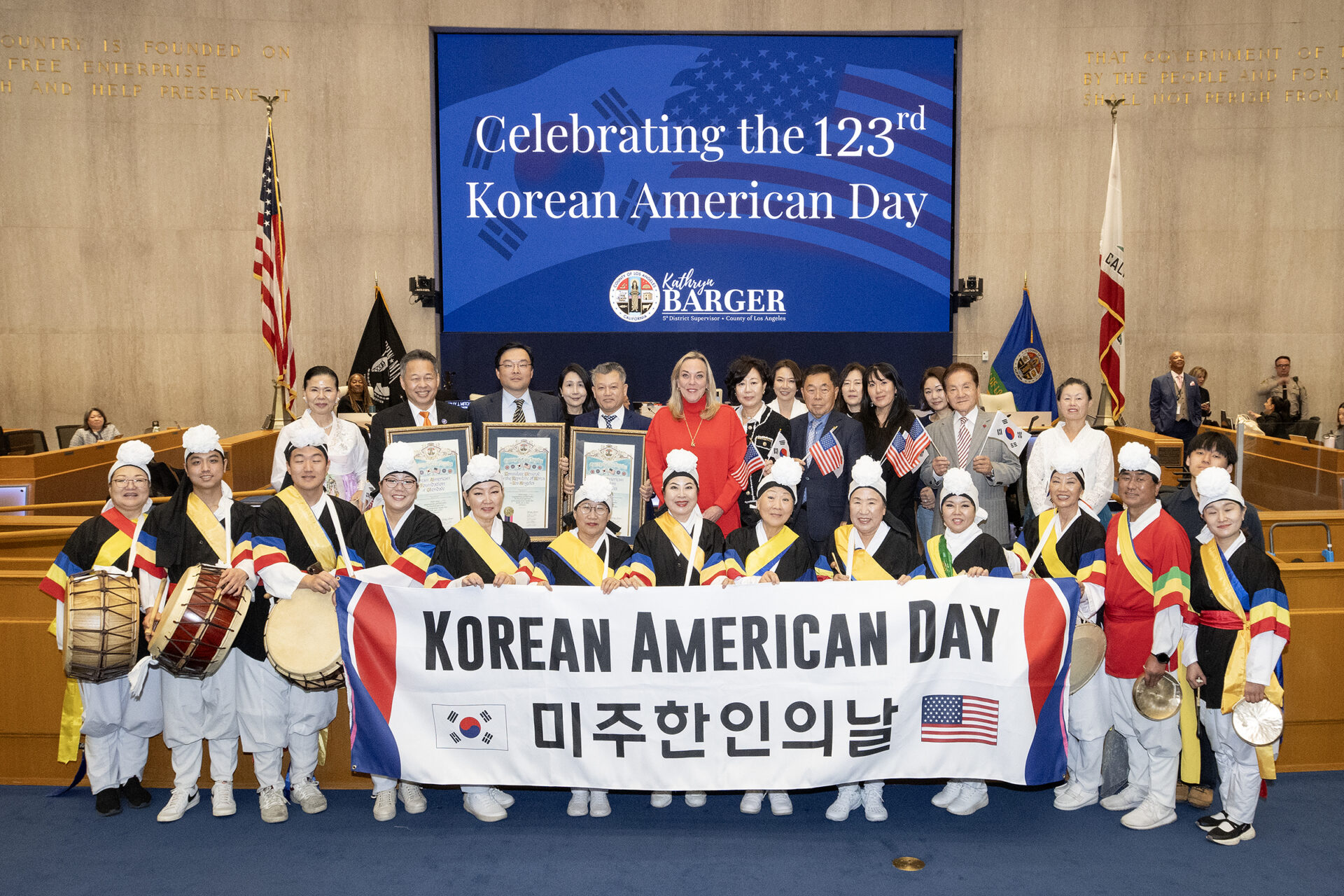 Supervisor Kathryn Barger poses with Korean American honorees and Samulnori percussion performers in the Board of Supervisors Hearing Room. (Photo credit: Diandra Jay/LA County)