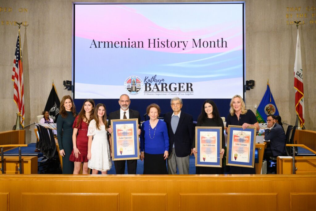 Supervisor Kathryn Barger presents commemorative scrolls to Armenian community honorees during a ceremony at the Los Angeles County Board of Supervisors. Pictured from left: Jill Panossian, Leah and Samantha Panossian, Dr. Andre Panossian and his parents, ServiceTitan representative Alene Aroustamian, and Supervisor Barger.